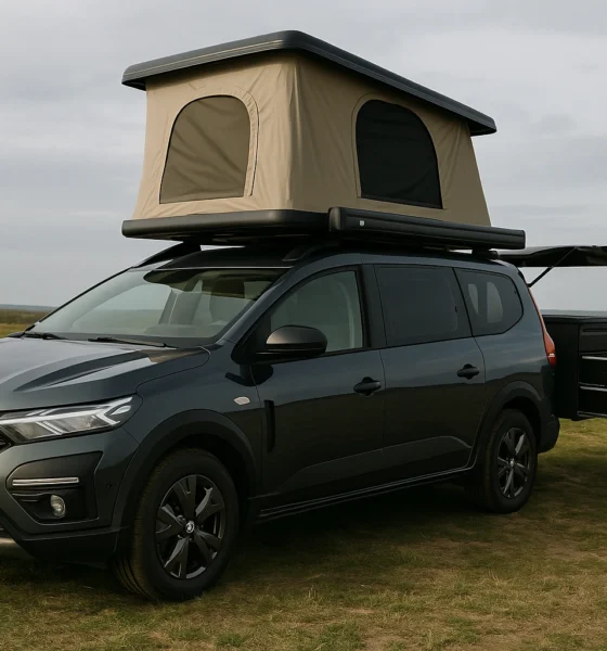 acia Sandman camping-car aménagé avec tente de toit, stationné sur un champ