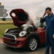 Mini Cooper rouge en panne capot ouvert vapeur mécanicien français route