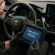 Technicien automobile utilisant une valise de diagnostic sur le siège conducteur d’une Toyota, affichant le code défaut P0299 à l’écran.