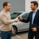 Un client remet les clés de sa voiture à un professionnel, avec une Renault Clio 5 en arrière-plan