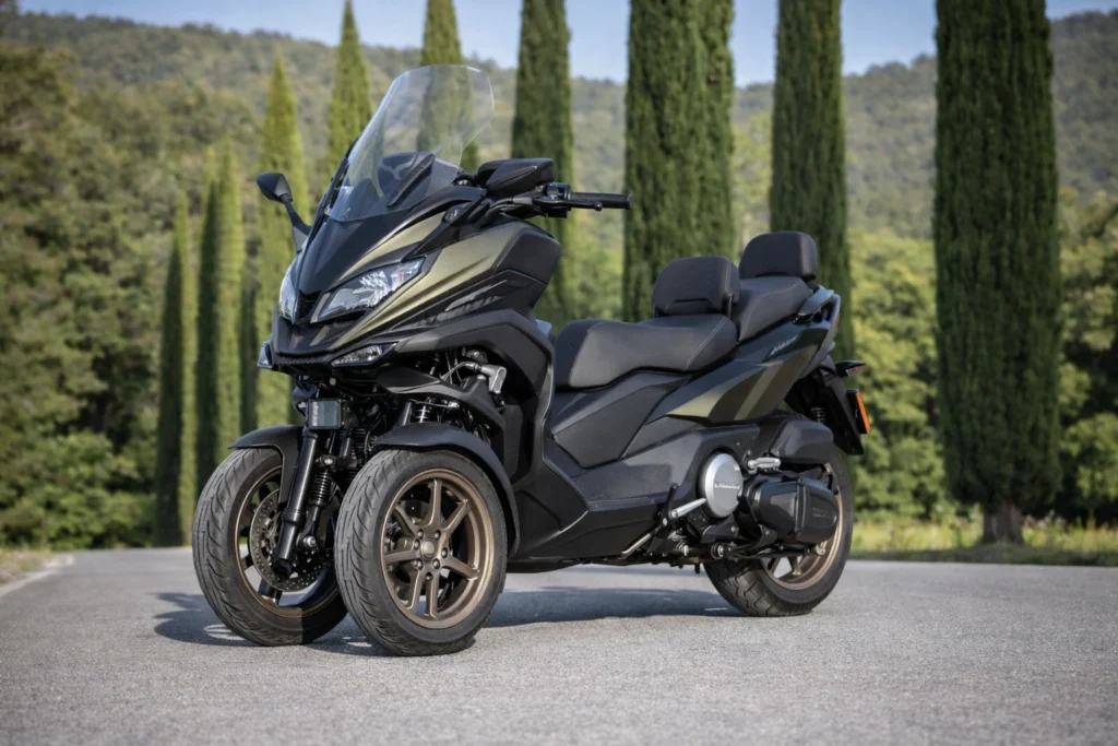 Quel scooter 3 roues choisir en 2026 ? Guide complet Maxi-scooter Kymco CV3 550 noir à trois roues stationné sur une route avec paysage naturel